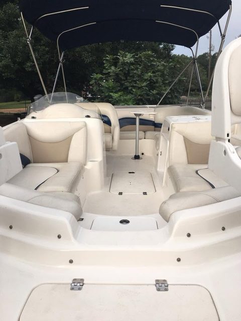 Boat deck with cream seats trimmed in navy under a bimini top