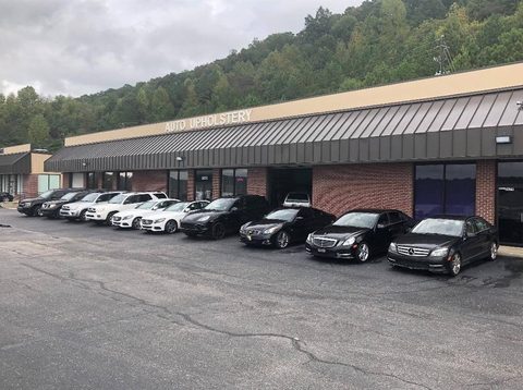 Row of cars parked outside the Auto Upholstery shop